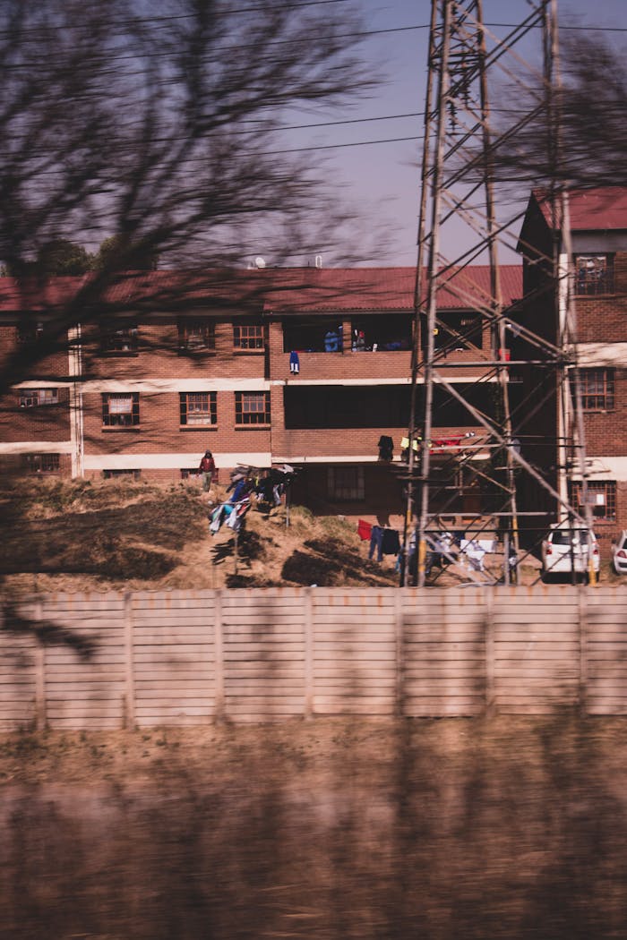 A blurred urban residential scene featuring laundry and power lines in Johannesburg.